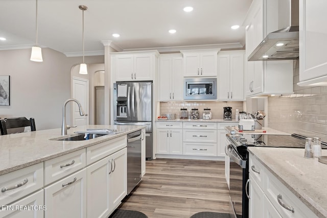 kitchen featuring light wood-style flooring, white cabinetry, crown molding, appliances with stainless steel finishes, and a sink
