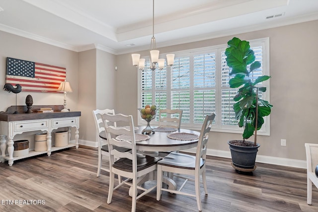 dining room with wood finished floors, baseboards, and visible vents