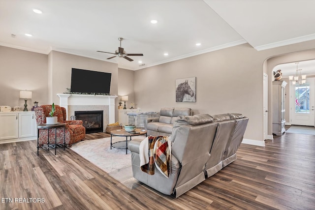 living room with baseboards, arched walkways, ceiling fan, wood finished floors, and a glass covered fireplace
