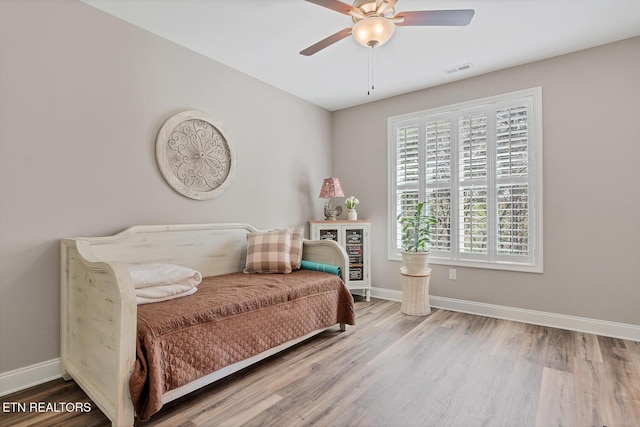 bedroom with visible vents, baseboards, a ceiling fan, and wood finished floors