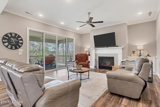 living room featuring crown molding, wood finished floors, ceiling fan, and visible vents