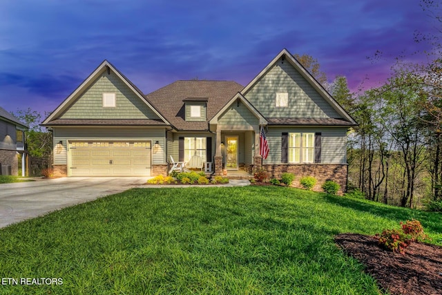 craftsman-style house featuring a front lawn, a shingled roof, an attached garage, and concrete driveway