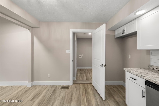 kitchen with light wood-style flooring, white cabinetry, visible vents, and dishwasher