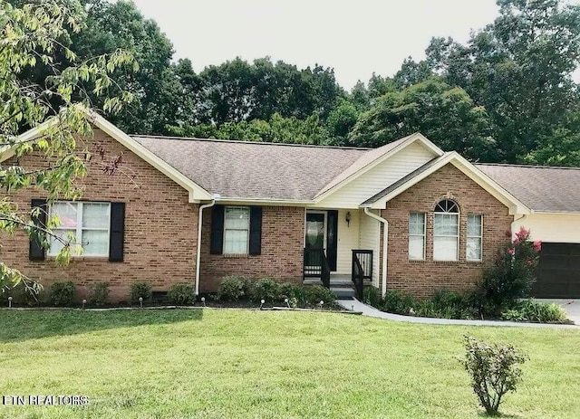 single story home featuring brick siding, a front lawn, a shingled roof, and a garage