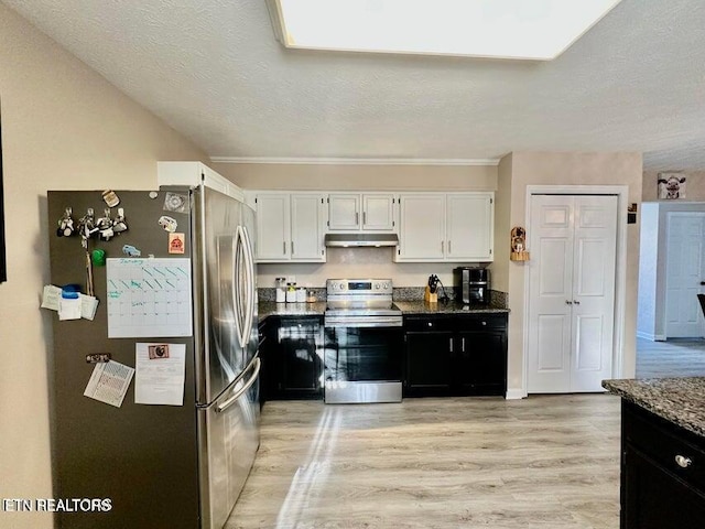 kitchen with dark cabinets, white cabinetry, appliances with stainless steel finishes, under cabinet range hood, and light wood finished floors