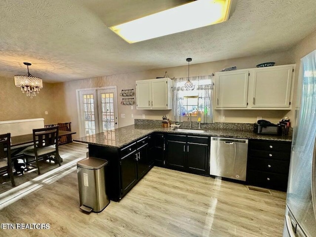 kitchen with stainless steel dishwasher, dark cabinets, light wood-type flooring, a textured ceiling, and white cabinetry