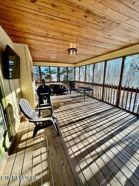 unfurnished sunroom featuring wooden ceiling and wood-type flooring