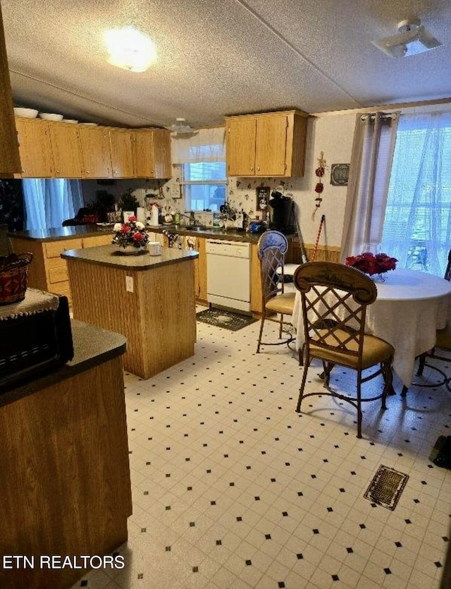 1274 Cedar Hills Rd, Dandridge, TN 37725 - kitchen featuring dishwasher, dark countertops, light floors, a center island, and a textured ceiling
