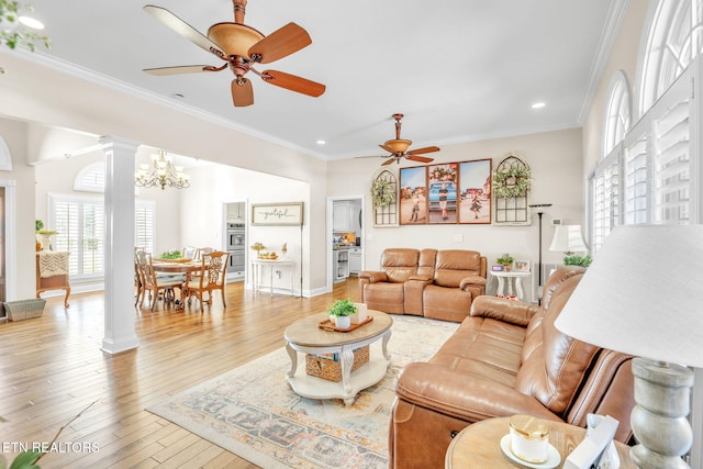 living room featuring decorative columns, recessed lighting, wood-type flooring, and ceiling fan with notable chandelier