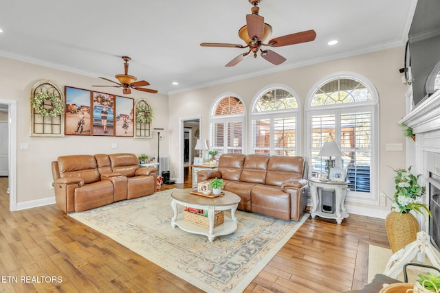 living room featuring crown molding, ceiling fan, a fireplace with flush hearth, recessed lighting, and light wood finished floors