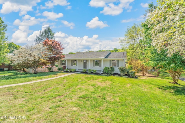 view of front of property featuring a porch, fence, and a front lawn