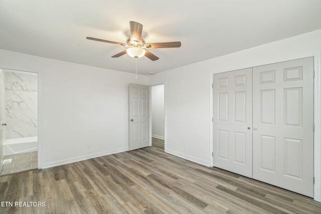unfurnished bedroom with a closet, baseboards, and wood finished floors