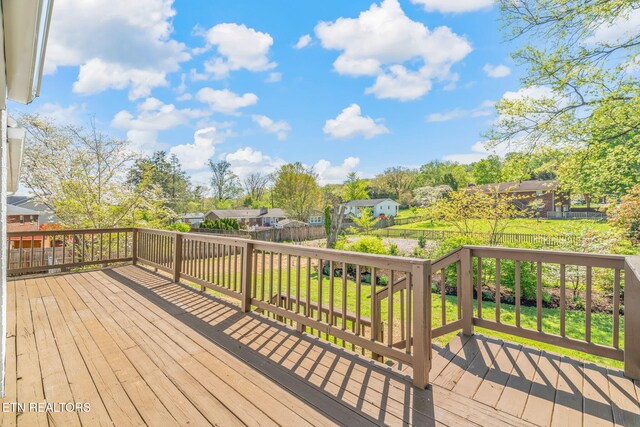 wooden terrace with a yard, a residential view, and a fenced backyard