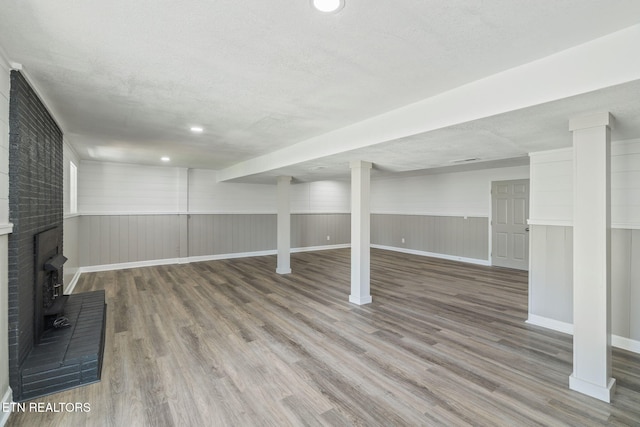 finished basement featuring a textured ceiling and wood finished floors