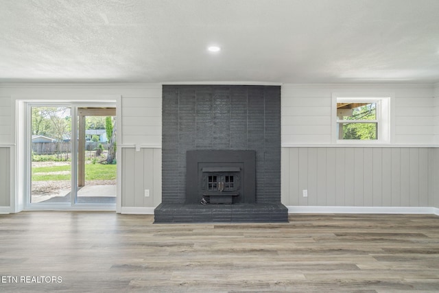 unfurnished living room featuring a fireplace, baseboards, and wood finished floors