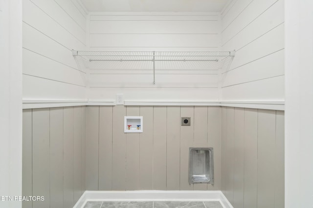 laundry area featuring wooden walls, hookup for an electric dryer, laundry area, and washer hookup