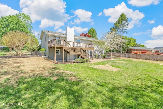 back of property with a fenced backyard, stucco siding, a lawn, stairs, and a deck
