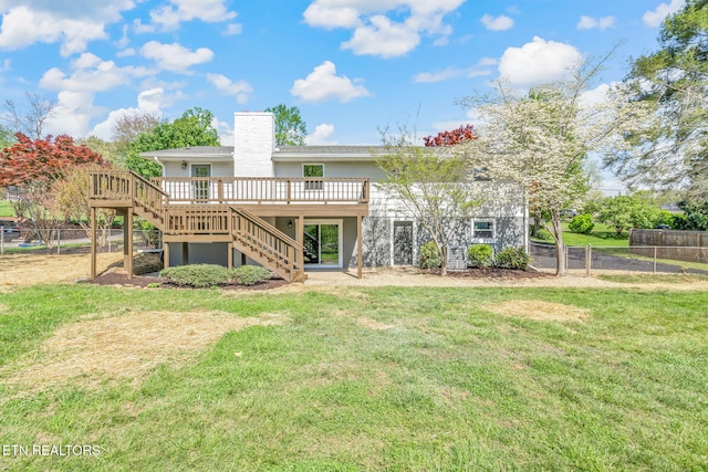 back of property with stairs, a yard, a wooden deck, and fence