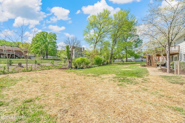 view of yard featuring fence, stairway, and a deck