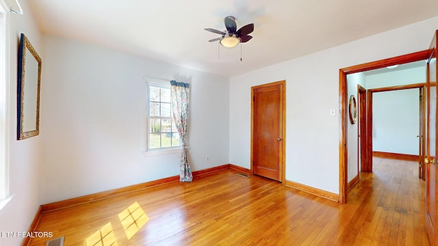 unfurnished bedroom with a ceiling fan, a closet, light wood-style flooring, baseboards, and visible vents