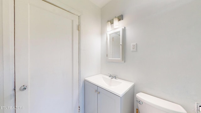 half bathroom featuring toilet and vanity