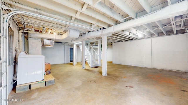 unfinished below grade area featuring stairway and washer / clothes dryer