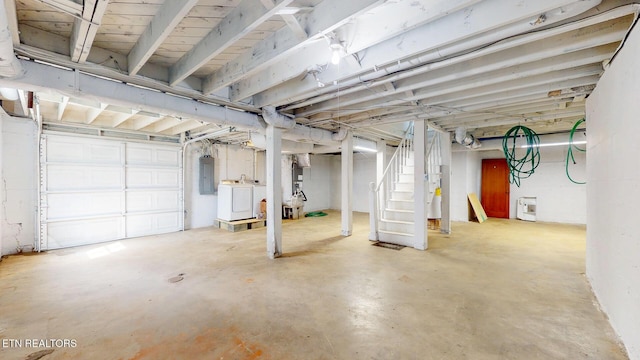 basement with electric panel, washer and dryer, and stairway