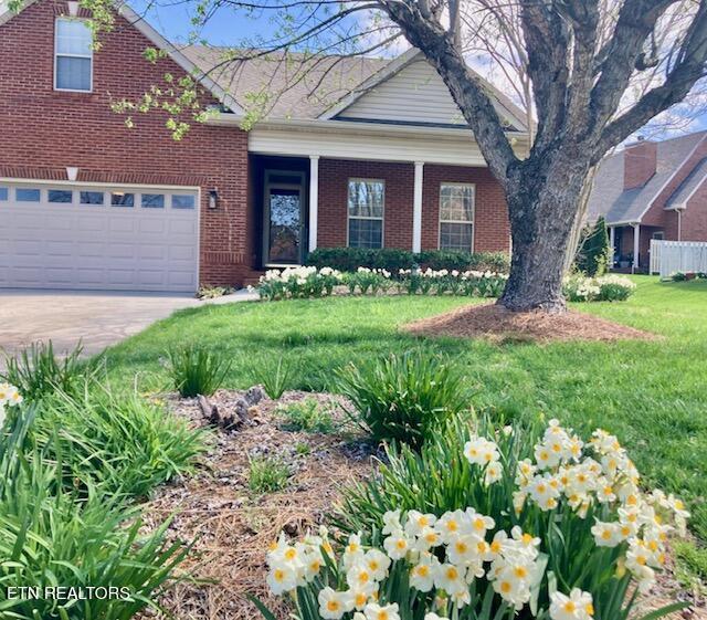 11608 San Martin Ln, Knoxville, TN 37934 - view of front of house featuring brick siding, concrete driveway, a front lawn, and a garage