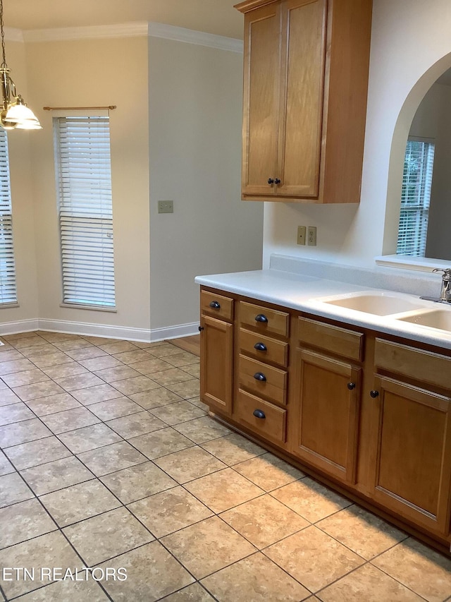 11608 San Martin Ln, Knoxville, TN 37934 - kitchen featuring crown molding, a sink, light countertops, arched walkways, and light tile patterned floors