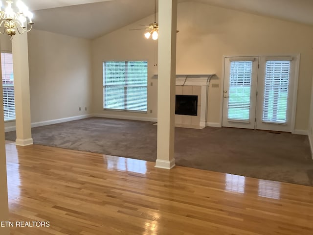 11608 San Martin Ln, Knoxville, TN 37934 - unfurnished living room with carpet flooring, a chandelier, wood finished floors, a tiled fireplace, and vaulted ceiling