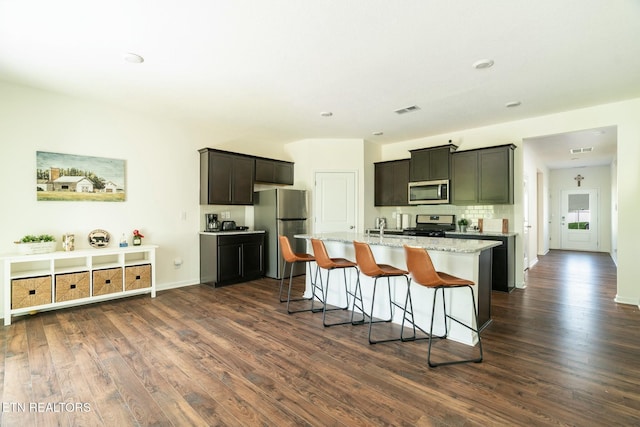 1133 Beacon Rd, Sevierville, TN 37876 - kitchen with a breakfast bar, visible vents, a center island with sink, dark wood finished floors, and appliances with stainless steel finishes