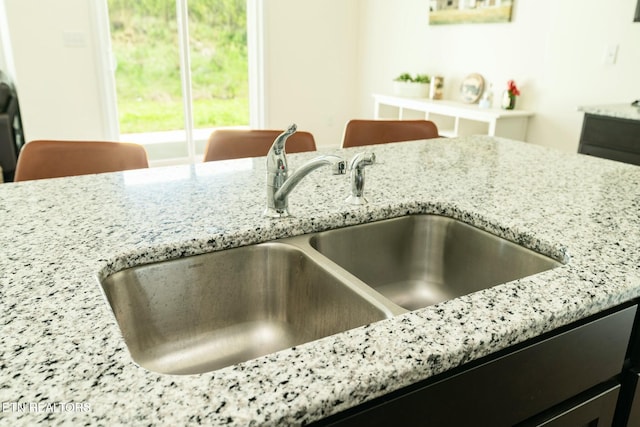 1133 Beacon Rd, Sevierville, TN 37876 - room details with light stone counters, a sink, and dark cabinets