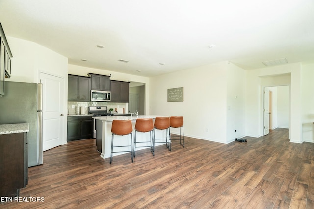 1133 Beacon Rd, Sevierville, TN 37876 - kitchen featuring dark wood-type flooring, a kitchen bar, appliances with stainless steel finishes, a kitchen island with sink, and a sink