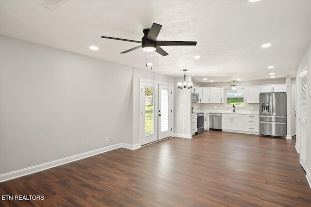 unfurnished living room featuring baseboards, recessed lighting, a textured ceiling, dark wood finished floors, and ceiling fan with notable chandelier