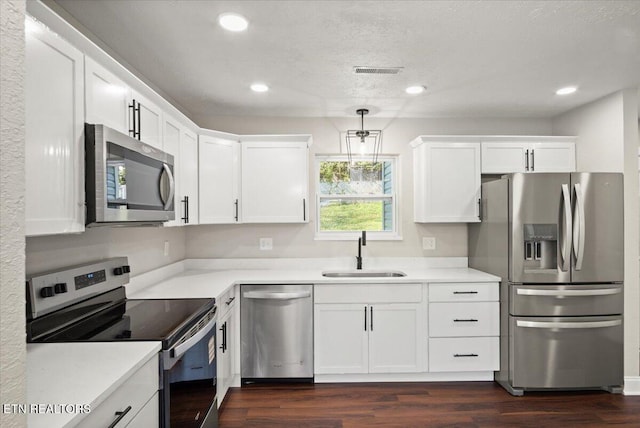 kitchen featuring stainless steel appliances, visible vents, white cabinets, and a sink