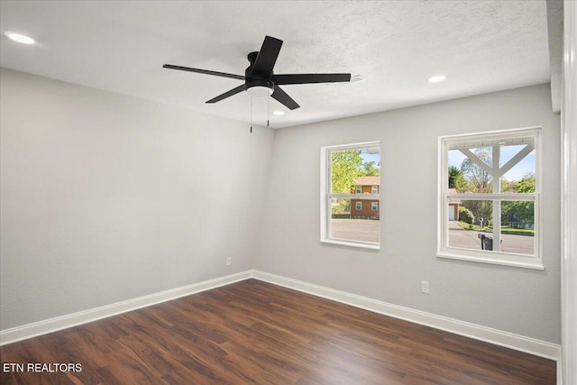 empty room with baseboards, dark wood-style floors, and a wealth of natural light