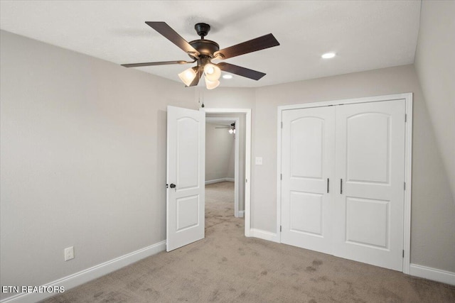 unfurnished bedroom with carpet floors, baseboards, a ceiling fan, and a closet