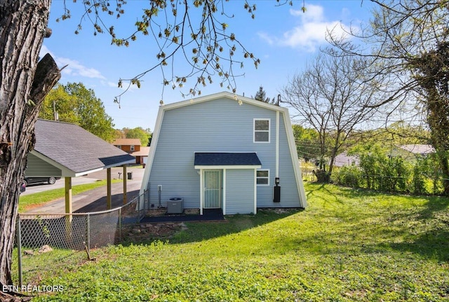 back of house featuring a yard, fence, and central AC