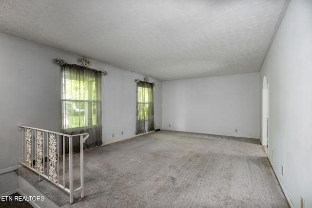 spare room featuring carpet floors and a textured ceiling
