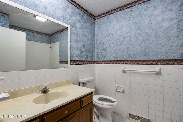 full bath with a tile shower, toilet, wallpapered walls, tile walls, and visible vents