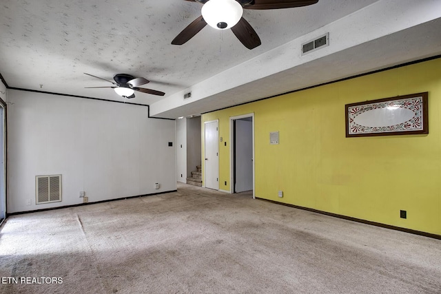 carpeted spare room with stairway, baseboards, ceiling fan, and visible vents