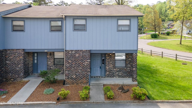 98 Hampshire Cir, Oak Ridge, TN 37830 - view of front facade with fence, a front lawn, brick siding, and roof with shingles