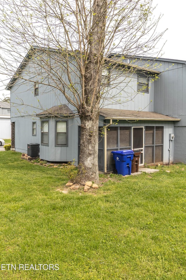 98 Hampshire Cir, Oak Ridge, TN 37830 - rear view of property with central air condition unit, a sunroom, roof with shingles, and a lawn