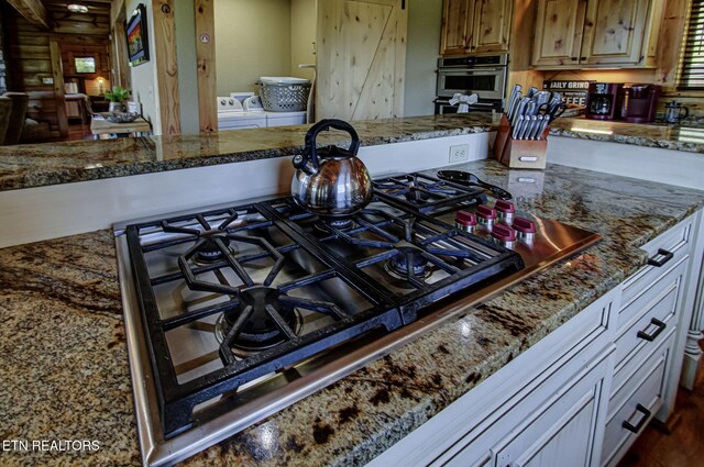 3505 Mountain Tyme Way, Sevierville, TN 37862 - kitchen with washing machine and dryer, stainless steel appliances, and stone counters