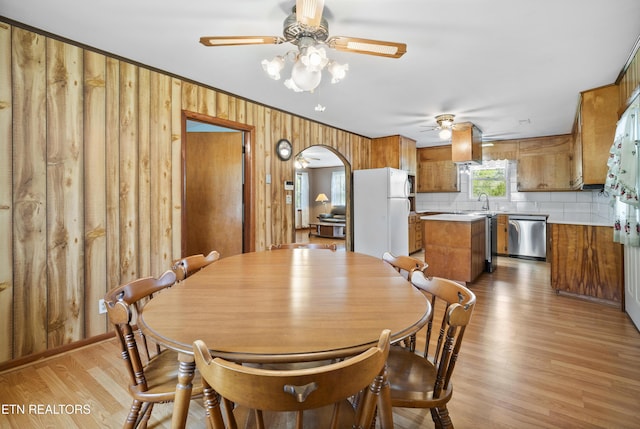 139 Hearon Rd, Kingston, TN 37763 - dining space with wooden walls, light wood-type flooring, a ceiling fan, and arched walkways