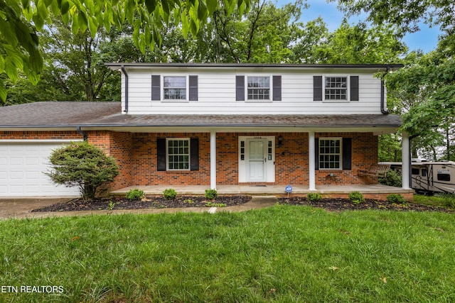 1104 Burning Tree Ln, Knoxville, TN 37923 - view of front facade with covered porch, brick siding, an attached garage, a front yard, and driveway