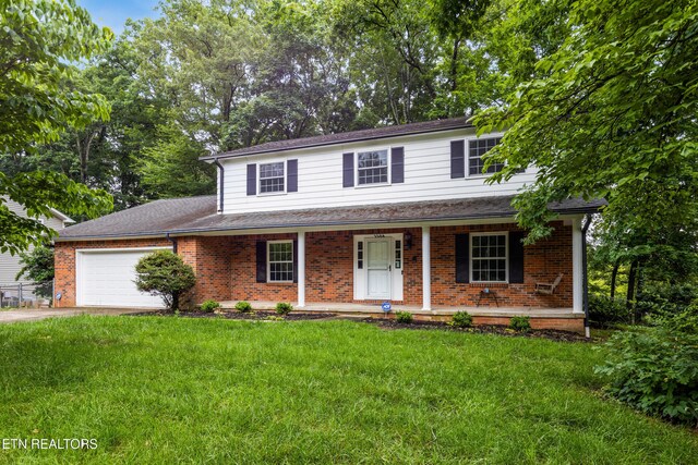 1104 Burning Tree Ln, Knoxville, TN 37923 - view of front of property with brick siding, covered porch, an attached garage, and a front lawn