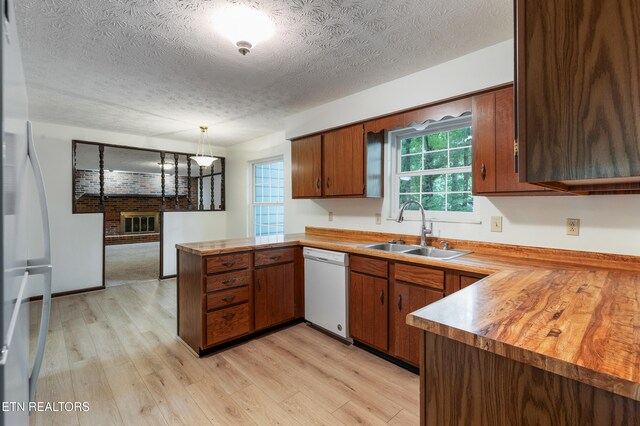 1104 Burning Tree Ln, Knoxville, TN 37923 - kitchen featuring a sink, white appliances, a peninsula, light wood-style floors, and a textured ceiling