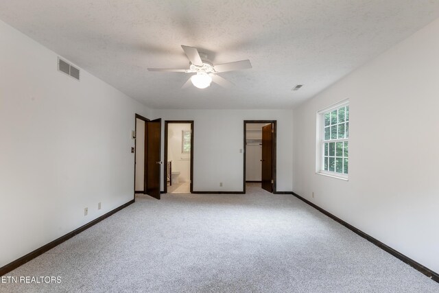 1104 Burning Tree Ln, Knoxville, TN 37923 - unfurnished bedroom with light carpet, baseboards, a textured ceiling, a walk in closet, and ensuite bath