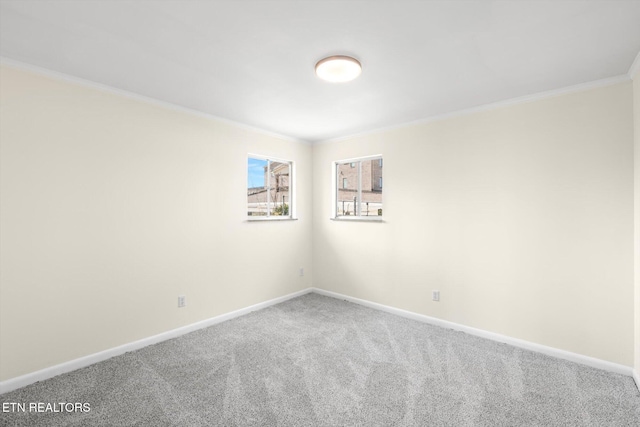 empty room with crown molding, baseboards, and carpet flooring